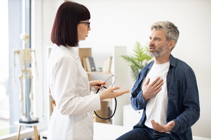 Homem explicando seus sintomas para a médica